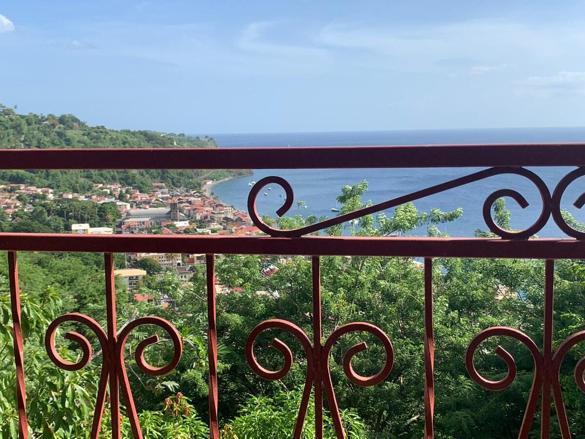 Vue sur la mer et le jardin depuis le balcon de la chambre Goyave